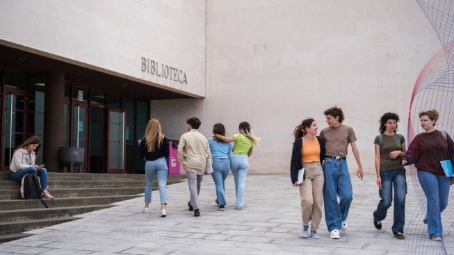 A group of people walking outside of a library.