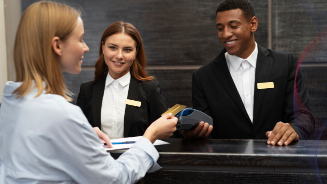 A person paying with a credit card at a hotel reception