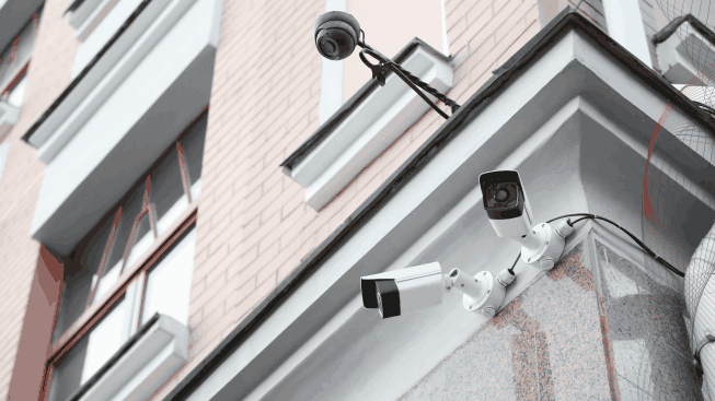 Modern cctv cameras on wall of building outdoors