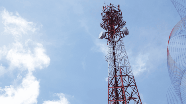 Telecommunications antenna for radio, television and telephone with cloud and blue sky in a background