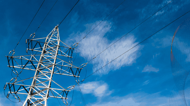 Electrical high voltage tower with wires on a cloudy blue sky background at sunny day