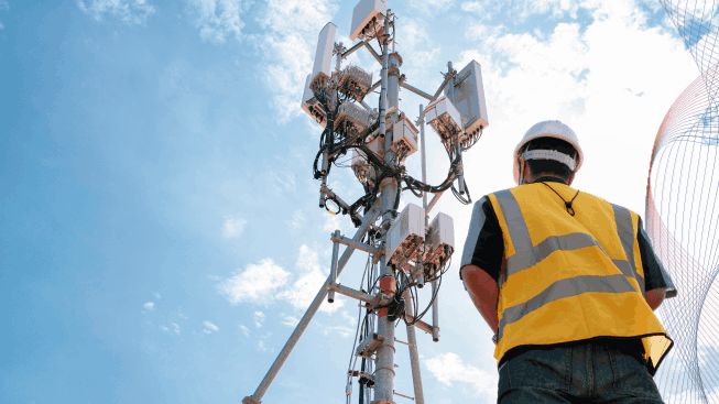 Male engineer in a field controls installations of telecommunication tower