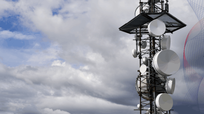 Telecommunications towers with cloudy sky in a background