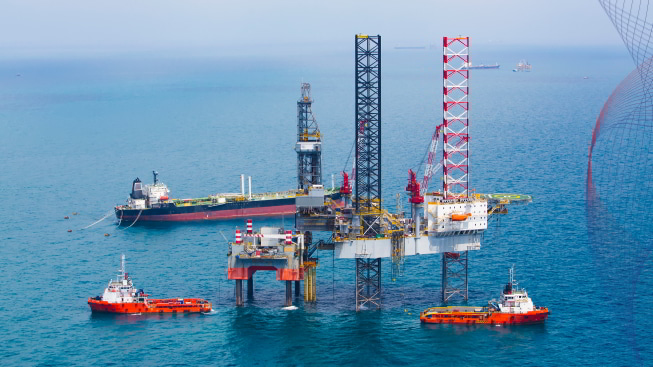 Oil rig in the gulf with ships in motion