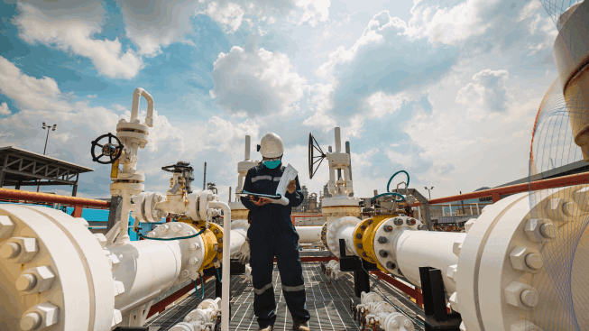 Male engineer inspection at steel long pipes and pipe elbow in station oil factory