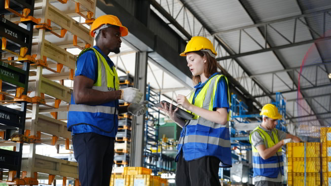 Two warehouse workers inside the warehouse checking the inventory