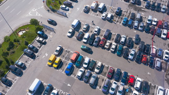 Plenty of cars in the parking lot in straight rows from a bird's-eye view