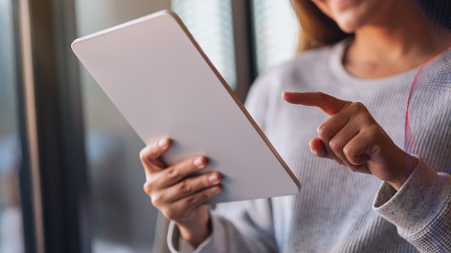 Closeup photo of a woman holding and using digital tablet