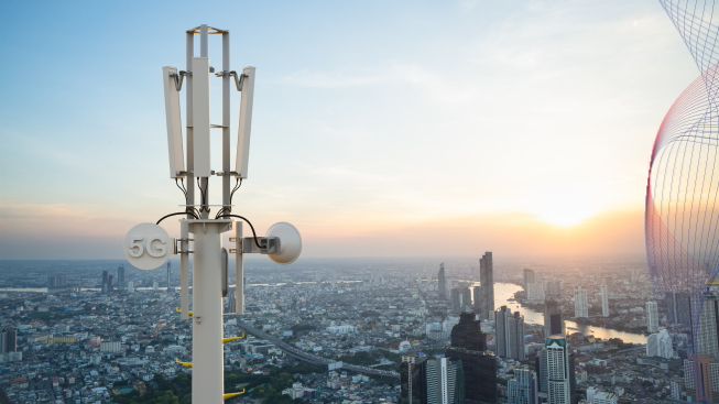 Telecommunication tower with 5g cellular network antenna on city background